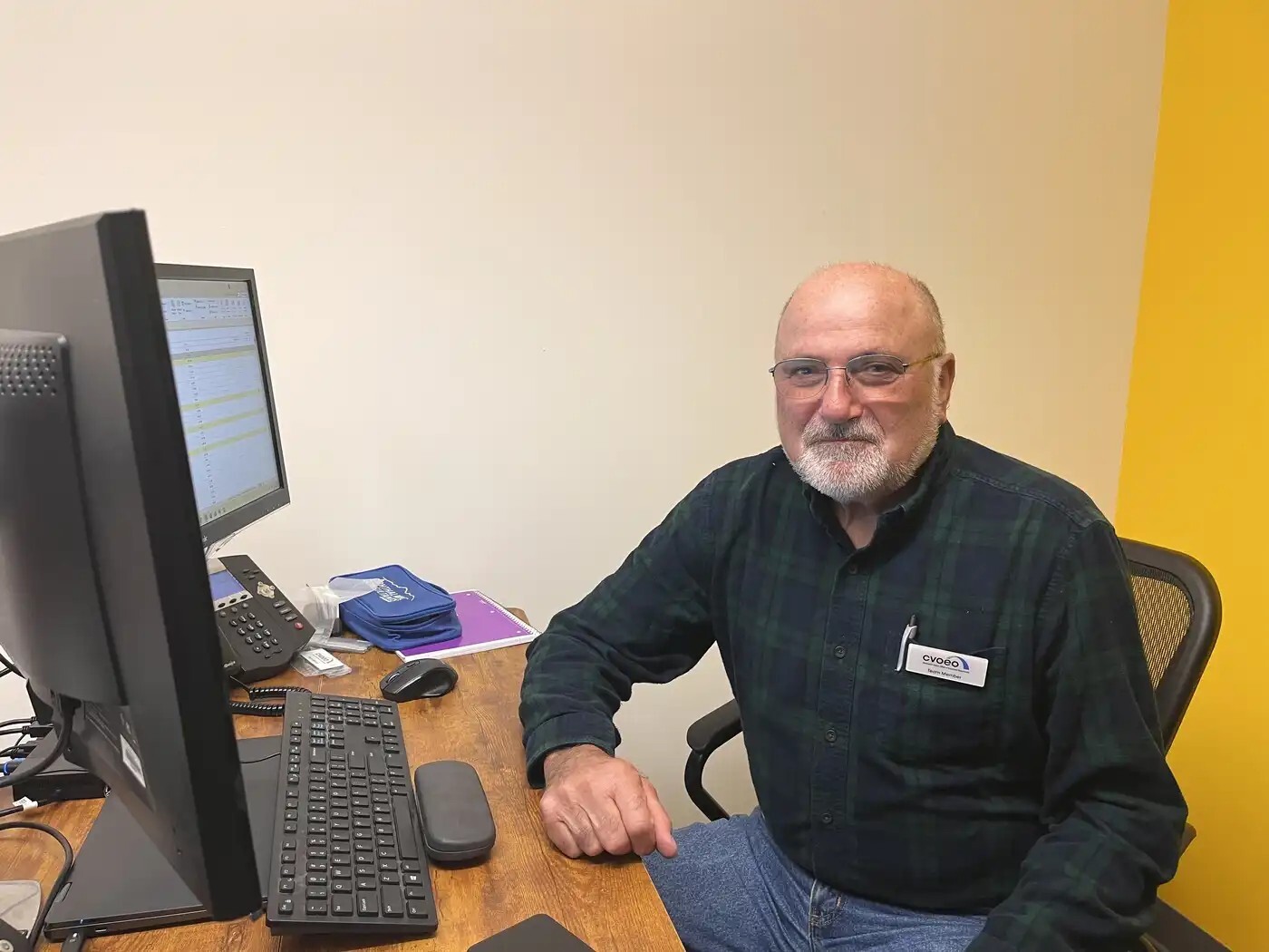 Staff member John Gergely seated at his desk.
